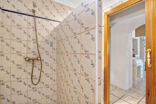 a bathroom with a tiled wall with blue writing on it at Bellavista 1016 in Oliva