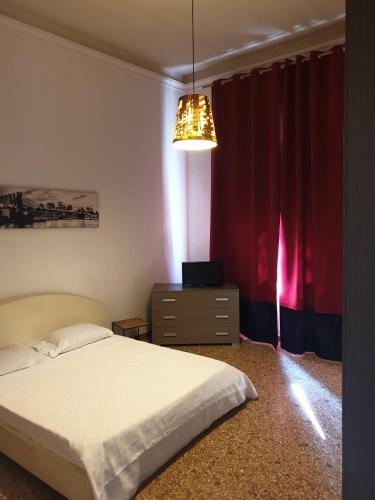 a bedroom with a bed and a red curtain at Angolo Relax Camere king in Rimini