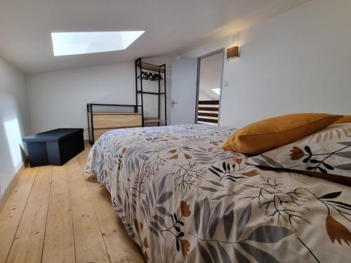 a bedroom with a bed with a comforter on it at Maison avec Extérieur - Stationnement Gratuit in Périgueux