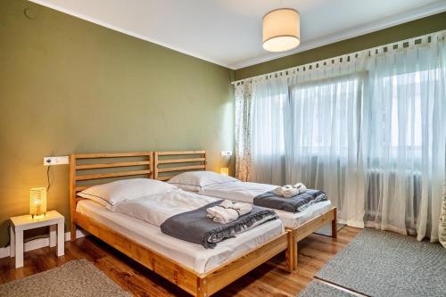 two beds in a bedroom with a large window at Apfelbaum in Friedrichshafen