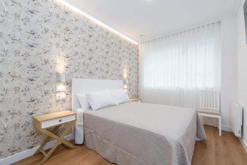 a bedroom with a bed and a wall with flowers at LUXURY SILGAR in Sanxenxo