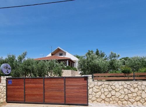 a wooden fence in front of a house at Holiday House DA & DO in Pakoštane