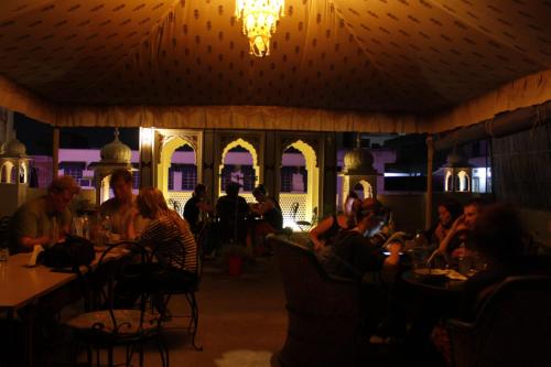 a group of people sitting at a table in a restaurant at Vinayak Guest House in Jaipur