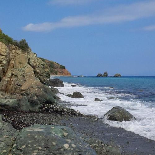 a beach with rocks and the ocean with waves at Manoleas Rooms to Let in Leonidion