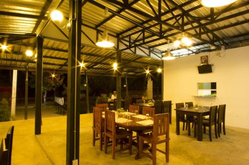 un comedor con mesas, sillas y luces en The Rise Resort, en Sukhothai