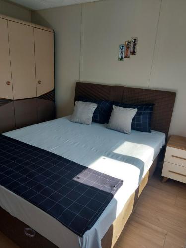 a bedroom with a large bed with blue sheets at Къщички Sunrise in Tsarevo