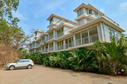 un coche blanco estacionado frente a un gran edificio en Fig House Anjuna-Chapora Road , Siolim 1BHK Suite en Oxel