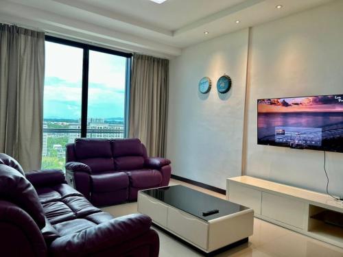 a living room with purple furniture and a flat screen tv at Jeff and Ricky Homestay 8 Boulevard Imperial Suites in Kuching