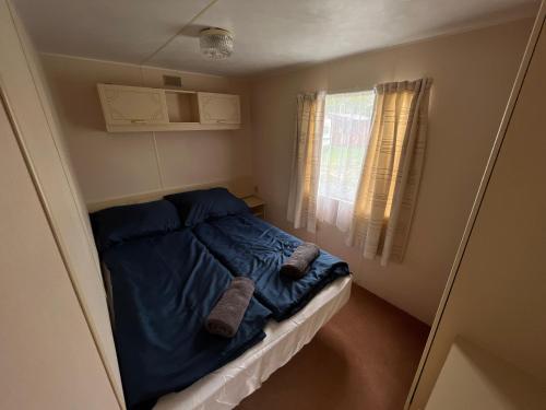 a small bedroom with a bed with a blue blanket at Autocamp Free Star - Mobilheimy in Strachotín