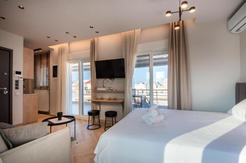 um quarto de hotel com uma cama grande e uma sala de estar em Harmonia by homebrain em Alexandroupoli