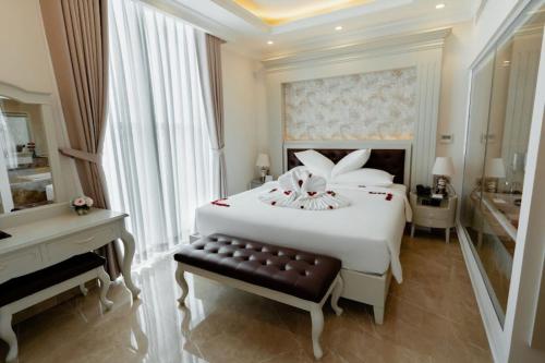 1 dormitorio con 1 cama blanca grande y piano en MerPerle Beach Hotel, en Nha Trang