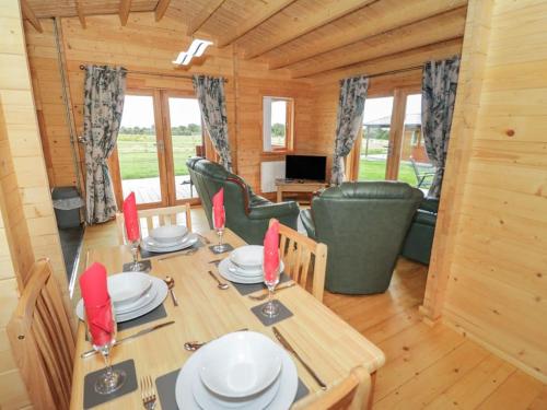 a wooden dining room with a table and chairs at Ty Mai, Parc Y Fronwen in Newborough