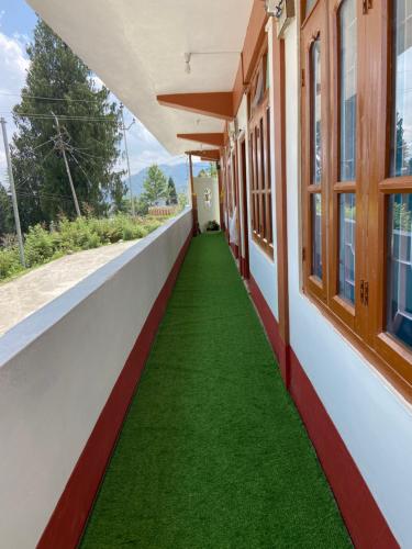 um corredor vazio de um edifício com relva verde em DPM HOMESTAY em Bomdila