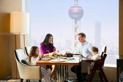 a family eating dinner at a table in a restaurant at The Ritz-Carlton Shanghai, Pudong in Shanghai