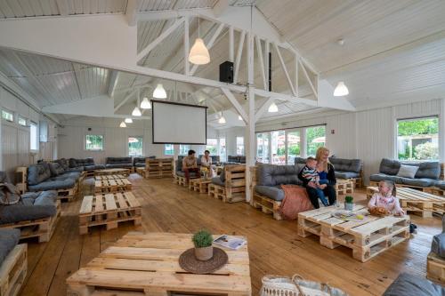 a living room with couches and tables and a screen at Camping Country Park Crecy La Chapelle - Site Officiel - Next to Disneyland Paris in Crécy-la-Chapelle