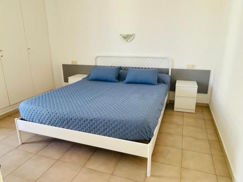 1 dormitorio con 1 cama grande con almohadas azules en Apartament L'Estartit - Costa Brava, en Torroella de Montgrí