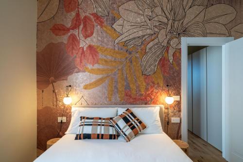 a bedroom with a bed with a flower mural on the wall at Aosta Holiday Apartments - Sant'Anselmo in Aosta