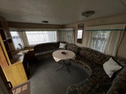 a living room with a couch and a table at Autocamp Free Star - Mobilheimy in Strachotín