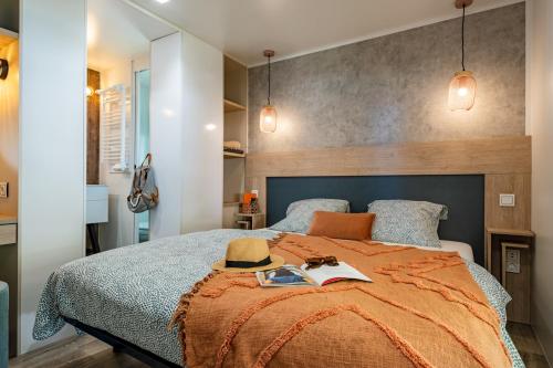 1 dormitorio con 1 cama con sombrero en Camping Country Park Crecy La Chapelle - Site Officiel - Next to Disneyland Paris en Crecy la Chapelle