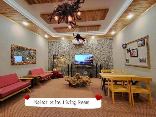 a living room with a table and a tv at Das-e-Basi in Gilgit
