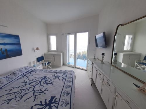 Habitación blanca con cama y espejo en La Luna sul Mare, Sea-Luxury Rooms, en Casteldaccia