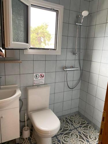 a bathroom with a toilet and a sink and a window at ANNA MARIA Studios in Potos