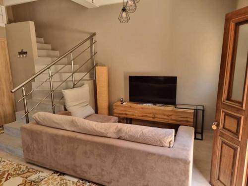 uma sala de estar com um sofá e uma televisão em Kavos House em Meyisti