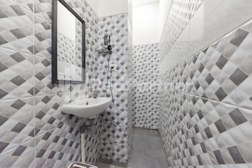 y baño con lavabo y espejo. en Maleo Residence Bandung Mitra RedDoorz, en Bandung