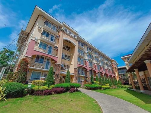 ein großes Apartmenthaus mit einem Garten davor in der Unterkunft Arezzo Place Davao Condominium in Davao City