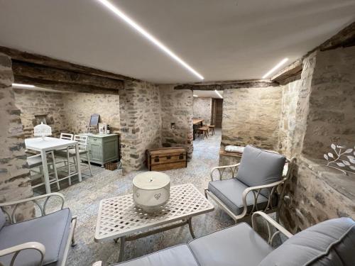 a living room with stone walls and chairs and a table at Appartamenti Gli Ippocastani in San Benedetto Belbo