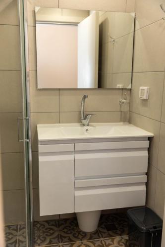 a bathroom with a white sink and a mirror at Saint Jacob Hotel in Nazareth
