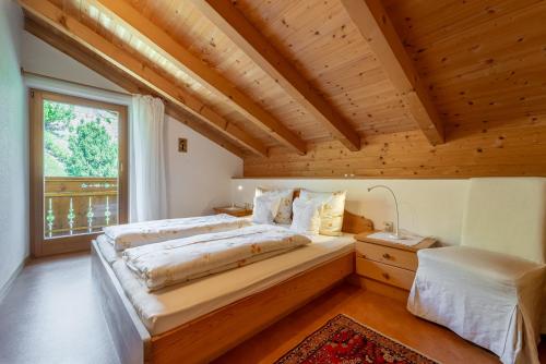 a bedroom with a large bed and a window at Haus Zenoburg in Tirolo