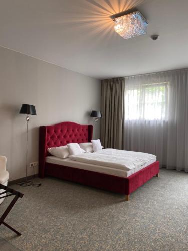 a bedroom with a large bed with a red headboard at Pałac na Wodzie Hotel & SPA in Jelenia Góra