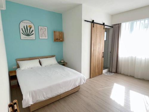 a bedroom with a bed and a blue wall at Good Stay in Tainan