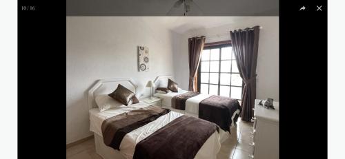 twee bedden in een kamer met een raam bij Amarilla Golf Suite in San Miguel de Abona