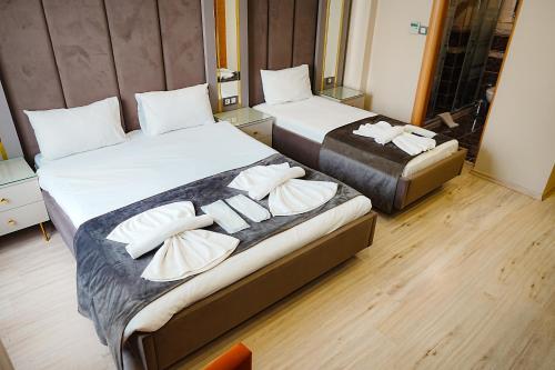 2 camas en una habitación de hotel con almohadas blancas en Reyyan Hotel, en Estambul