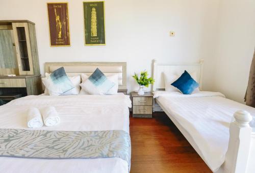 Duas camas num quarto com lençóis brancos e almofadas azuis em Mountain City View @ THE LOFT IMAGO, 2bedroom 5pax em Kota Kinabalu