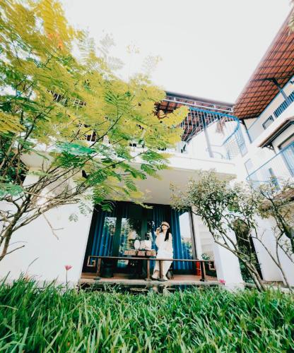 two women standing on a balcony of a building at La Y Riverview in Hue