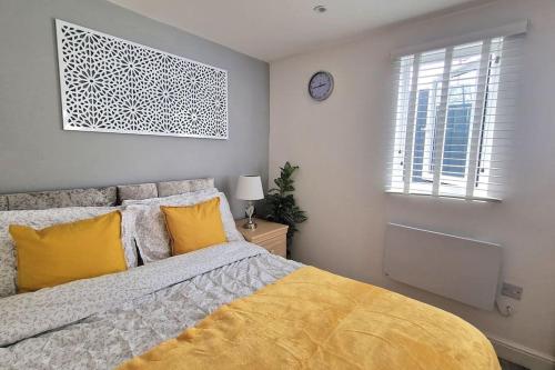 a bedroom with a bed with yellow pillows and a window at Private Garden Studio near London free Freeparking in West Thurrock