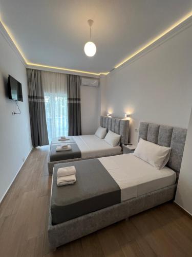 a bedroom with two beds and a couch at Vila Melina in Ksamil