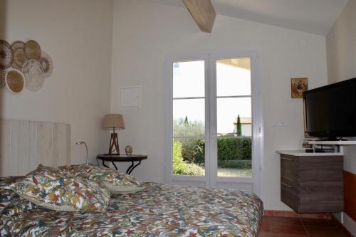 una camera con letto, televisore e finestra di Provence.bienvenue chez nous a Rognes