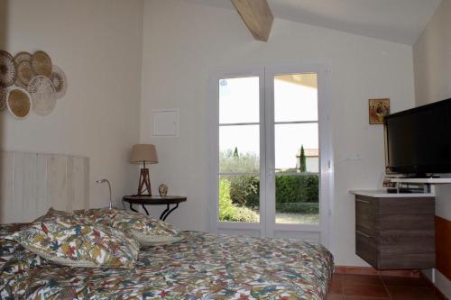 a bedroom with a bed and a television and a window at Provence.bienvenue chez nous in Rognes