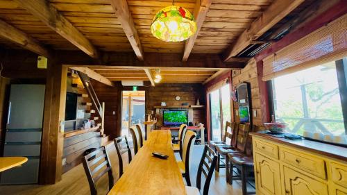 a dining room with a long wooden table and chairs at ログあした 船でしか行けない離島のヴィラ in Hinase