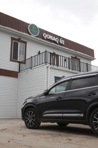 a black suv parked in front of a building at Jardin in Aktobe