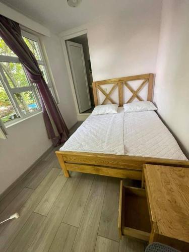 ウレキにあるQiwi Houseの木製のフレームの大きなベッドのある寝室