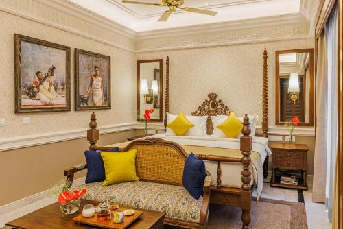 a bedroom with a bed with yellow and blue pillows at Raajkutir - IHCL SeleQtions in Kolkata