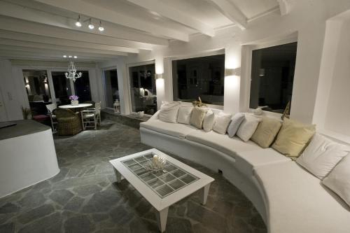 ein Wohnzimmer mit einem weißen Sofa und einem Tisch in der Unterkunft Villa Margarita in Mykonos Stadt