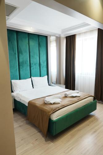 a bedroom with a large bed with a green headboard at Reyyan Hotel in Istanbul