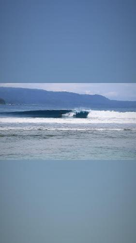 a wave in the ocean on a beach at Rumah Nalu surf camp in Krui