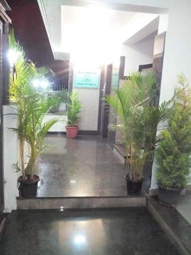a hallway with potted plants in a building at ZIONS APARTMENT in Devanahalli-Bangalore